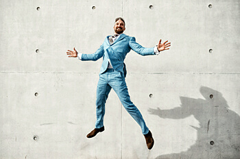 Mann in Anzug schwebt vor Mauer