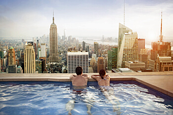 Schwerpunkt Tourismus zwei Personen in einem Pool genießen die Aussicht auf die Skyline Manhattans